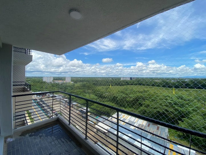 Balcón amplio con malla de seguridad instalada de piso a techo y vista panorámica