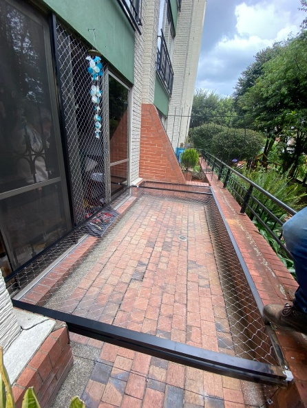 Patio en ladrillo con malla de seguridad instalada en todo el perímetro